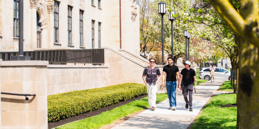 Students walk past an academic building.