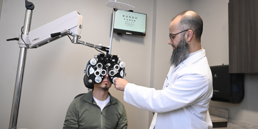 An optometry professor examines a patient in the clinic.